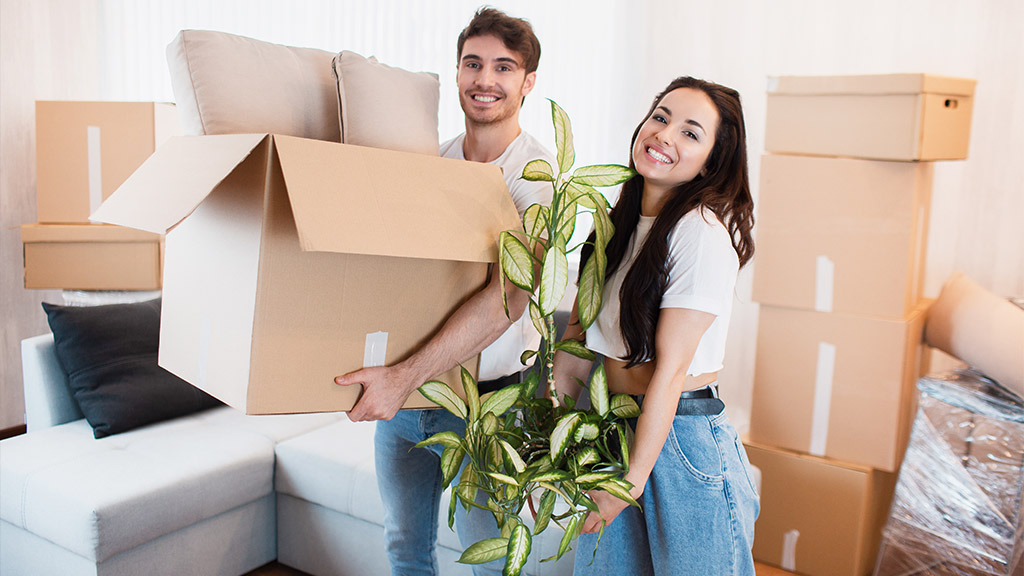 happy-couple-with-cardboard-boxes-in-new-house-at-moving-day